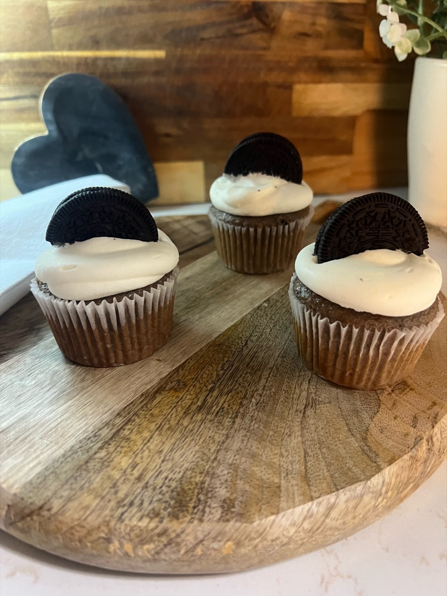 Chocolate cupcakes with vanilla frosting topped with a chocolate sandwich cookie